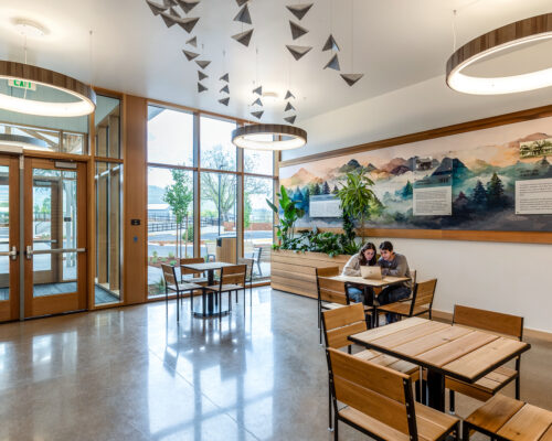 Student seating area with tables and wall graphics inside SOESD Phoenix campus