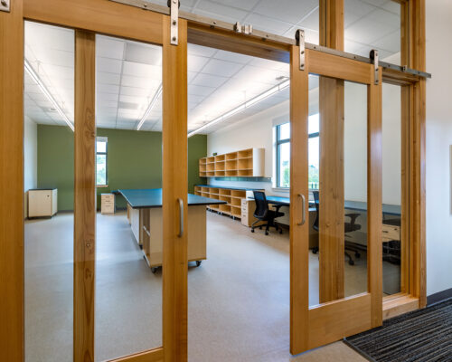 Flexible classroom space with wood sliding door and built-in workstations at SOESD Phoenix campus