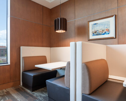 Built-in work booths with upholstered seating and custom wood wall panels