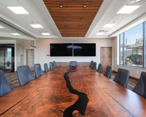 Boardroom with a live-edge conference table and custom wood ceiling detail