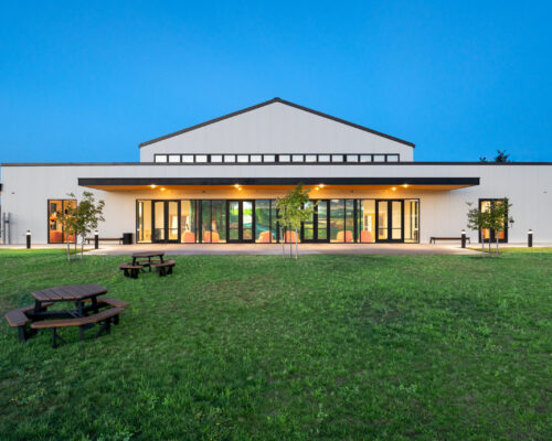 Performing Arts and Learning Center viewed across the campus lawn at dusk