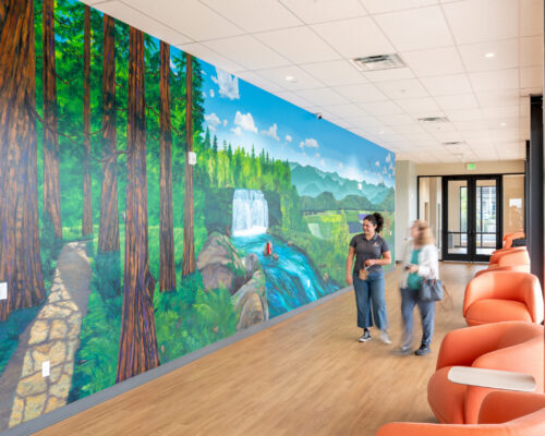 People viewing the Southern Oregon landscape mural in the student commons