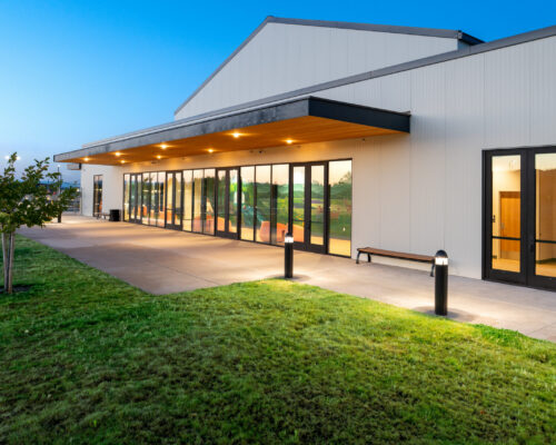 Covered patio and exterior doors connecting the building to the campus lawn