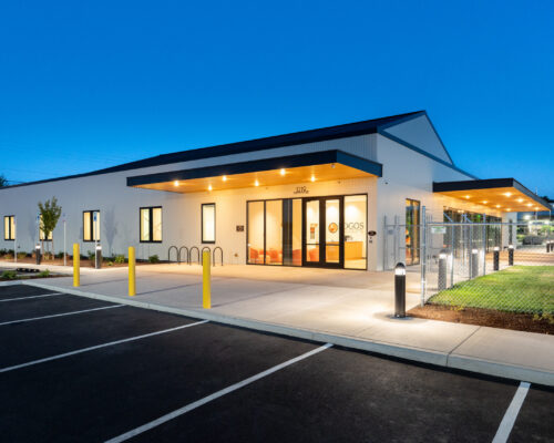 Illuminated main entrance to the Logos Performing Arts and Learning Center at dusk