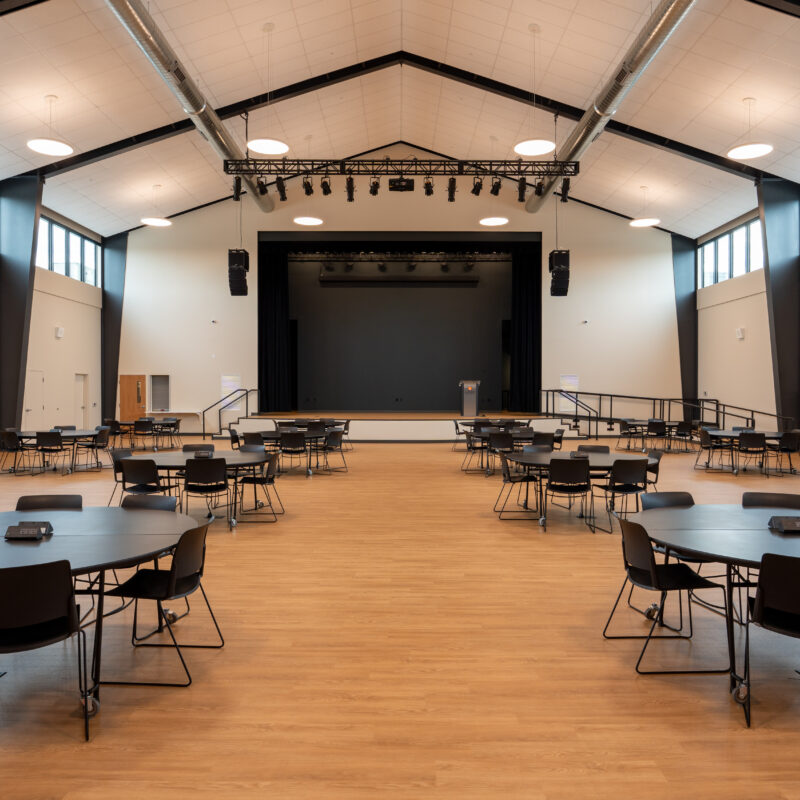 Multipurpose performance space with stage, theatrical lighting, and movable seating