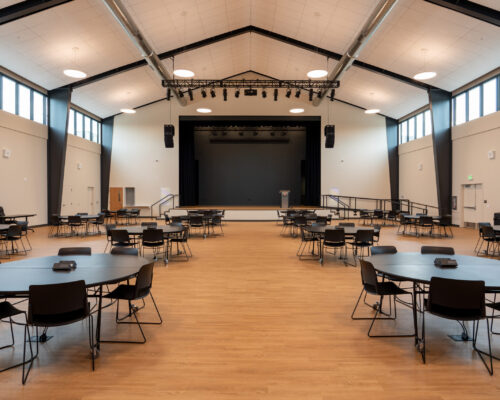 Multipurpose performance space with stage, theatrical lighting, and movable seating